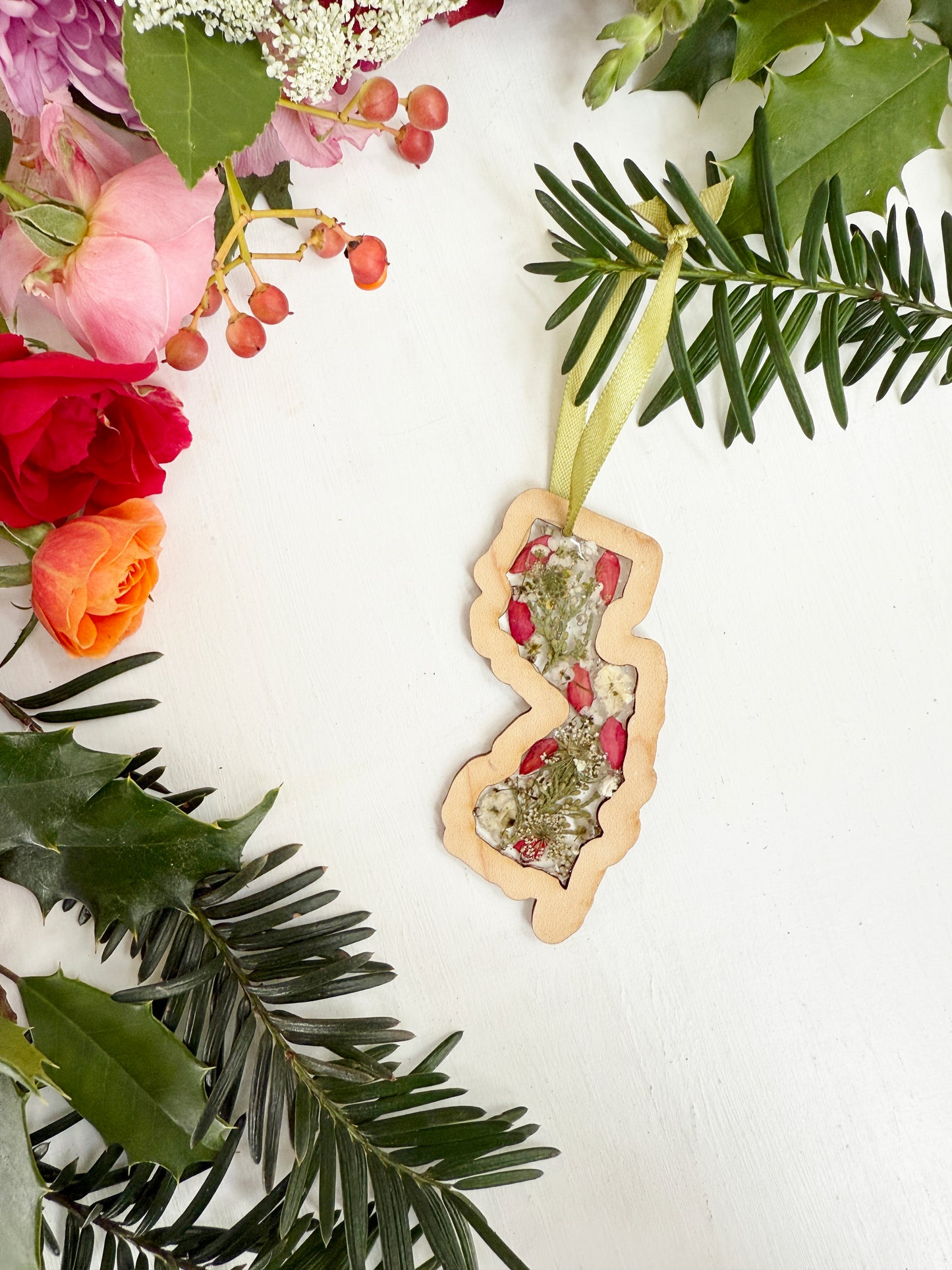 Christmas ornament in the shape of New Jersey filled with real flowers in resin