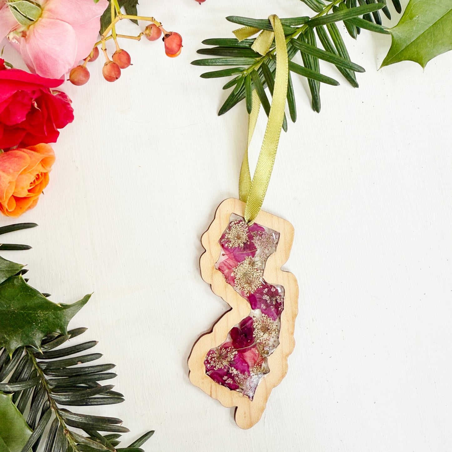 Christmas ornament in the shape of New Jersey filled with real flowers in resin