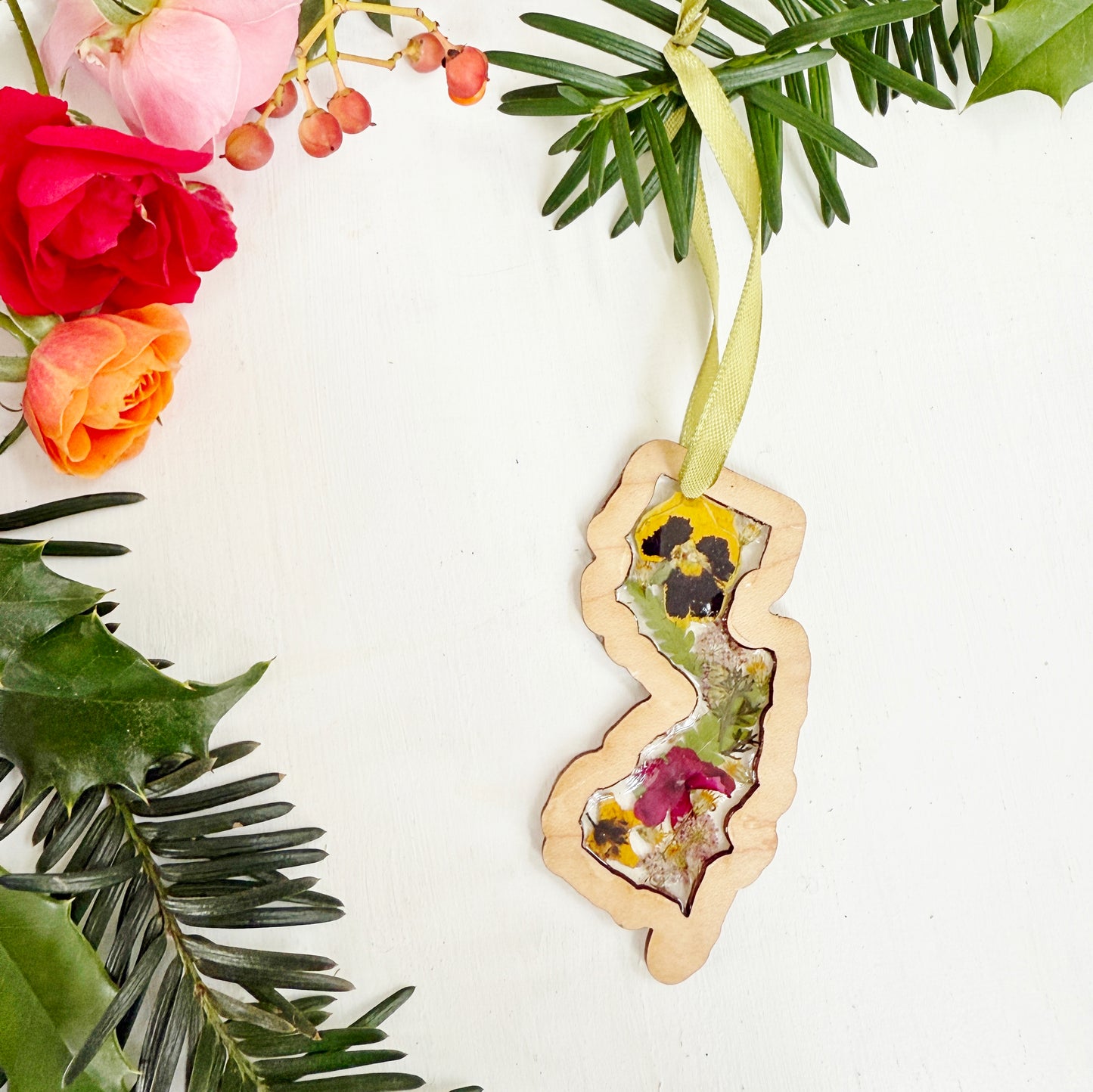 Christmas ornament in the shape of New Jersey filled with real flowers in resin