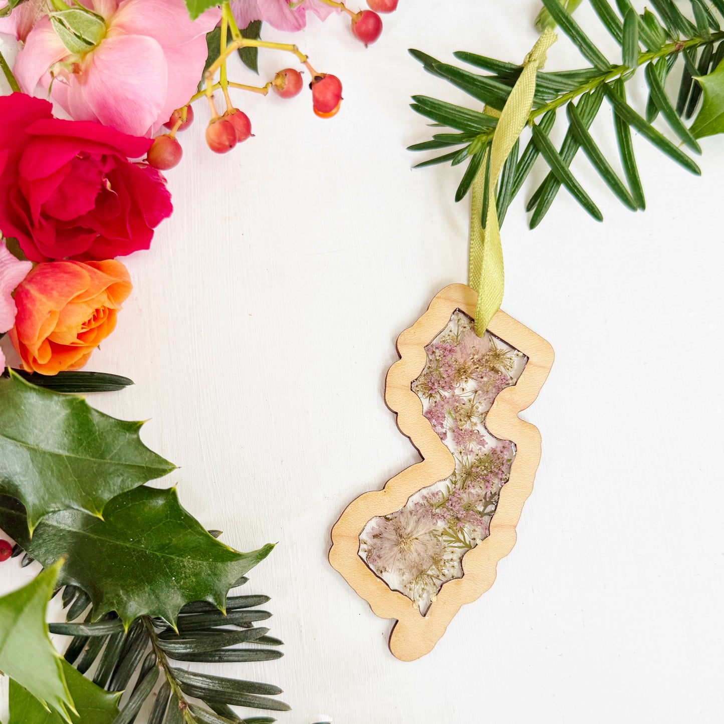 Christmas ornament in the shape of New Jersey filled with real flowers in resin