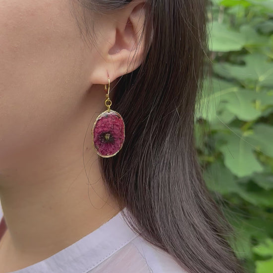 Real poppy earrings in golden frame on a model