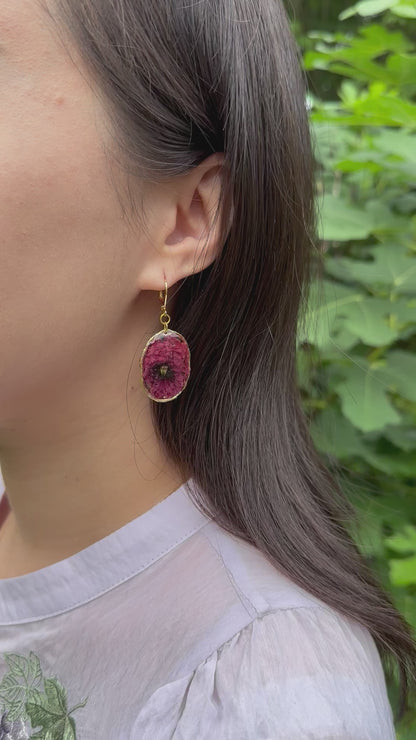 Real poppy earrings in golden frame on a model